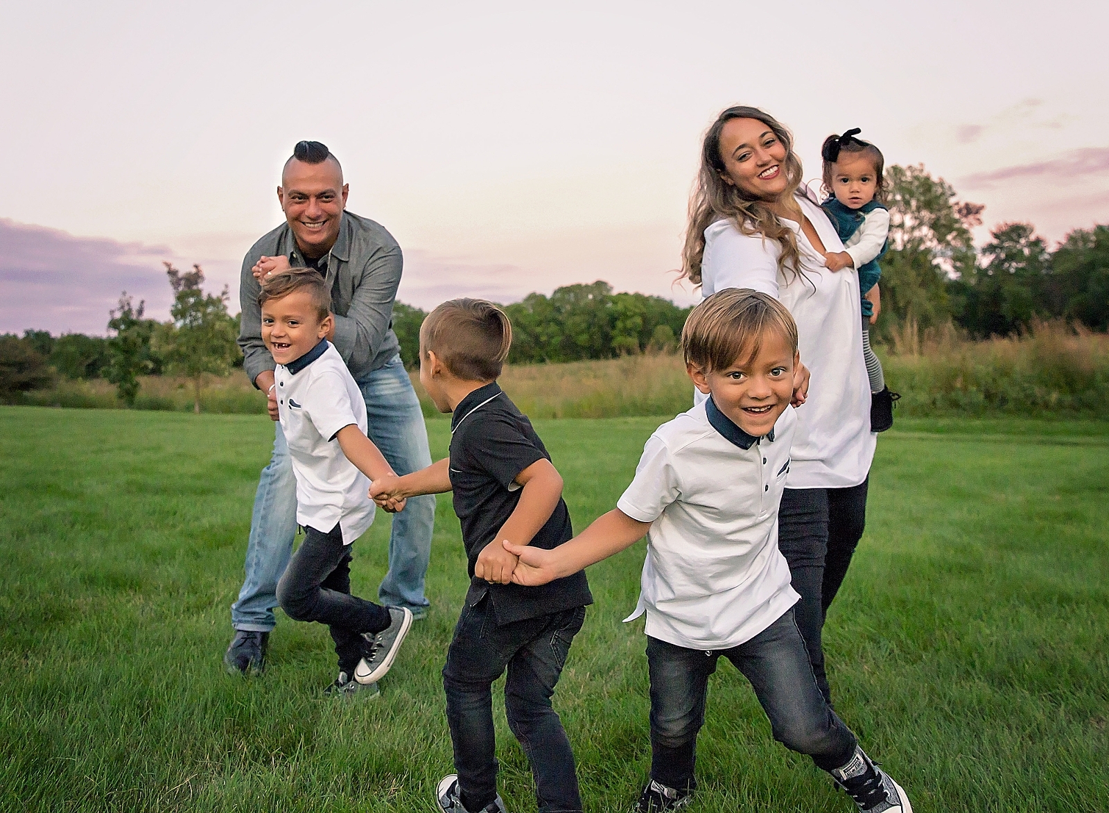 Family with 4 kids playing in a field.